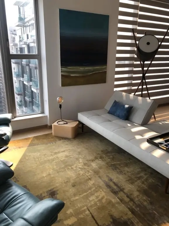 Contemporary living room with a golden-brown custom rug by Rug Your Life, bright natural light, and modern furniture.