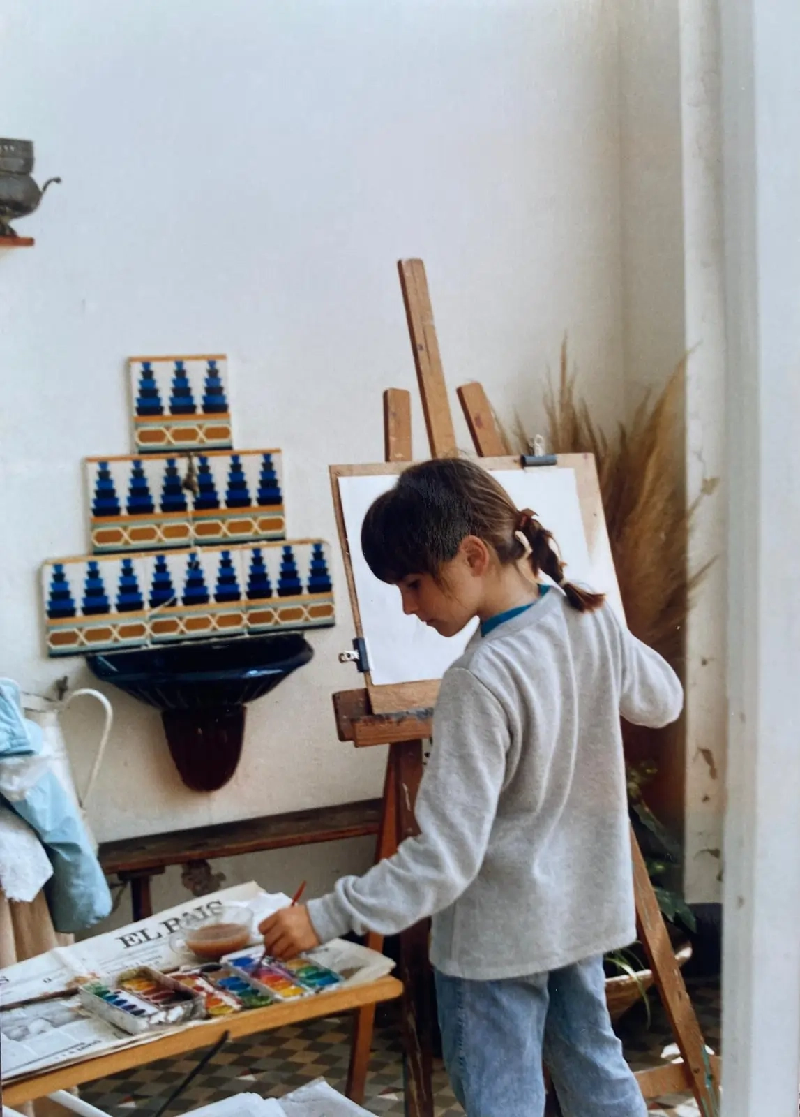 Young girl painting on a canvas in her home
