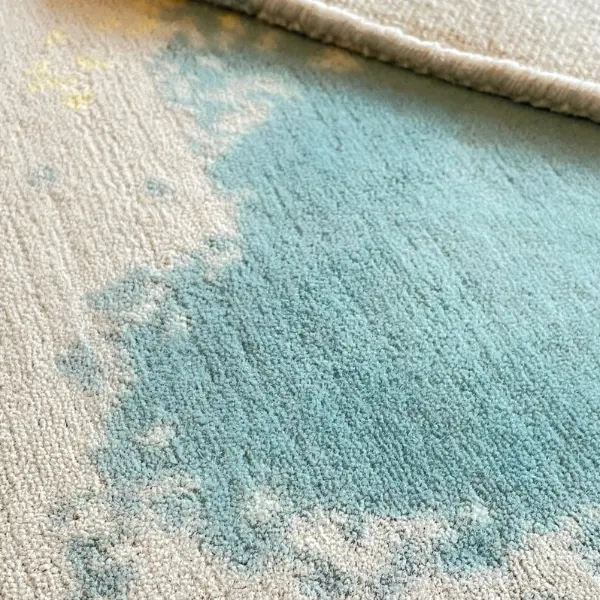 Closeup to handknotted rug in fine, soft wool. Base colour is cream and design in turquoise blue