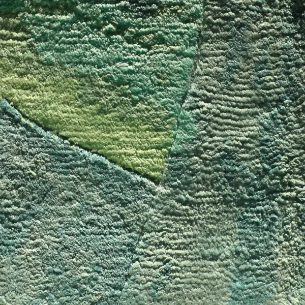 Handknotted rug in pure tencel in green and turquoise shades, in afternoon light