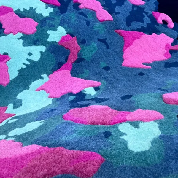 Handtufted rug in wool, with blue base and pink areas in higher pile