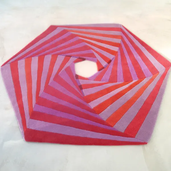 Hexagon shaped rug in pink and red shades, Swirl rug by Annika Johansson