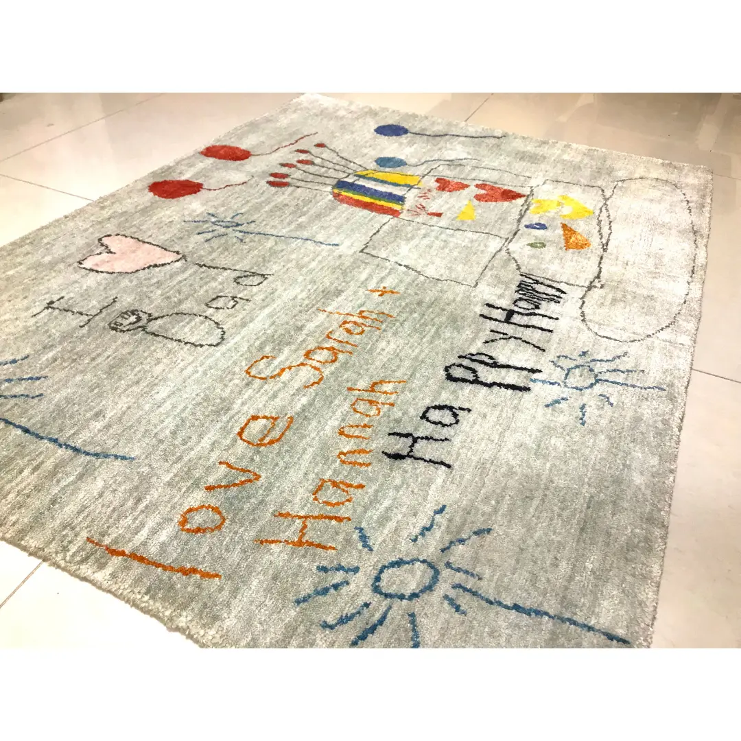 Vista lateral de una alfombra gris verdosa hecha a mano a partir de una preciosa obra de arte infantil