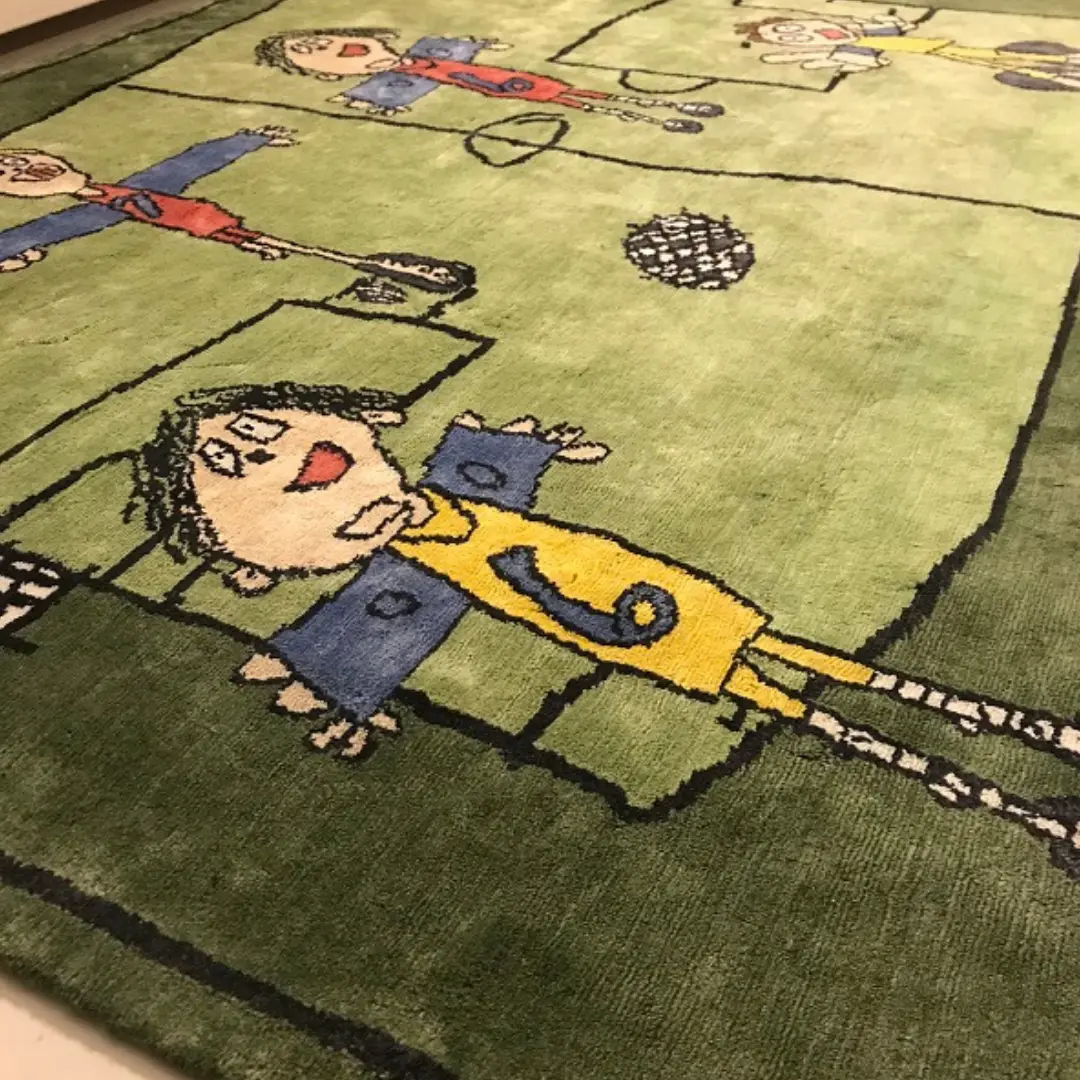 Vista lateral de la alfombra hecha a mano a medida inspirada en el arte infantil y el dibujo de jugadores de fútbol