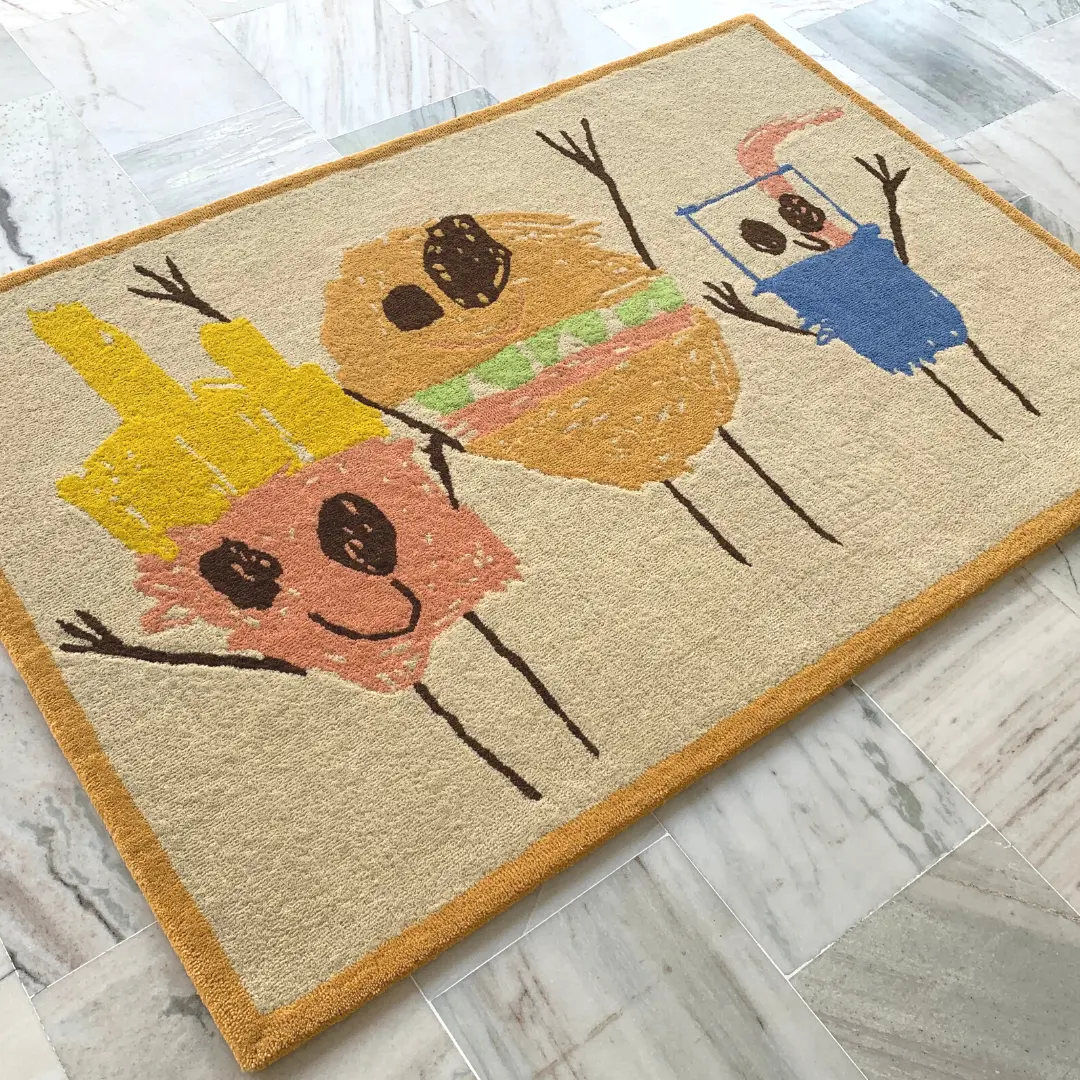Alfombra dulce hecha a mano y basada en dibujos del propio niño con patatas fritas, hamburguesa y refresco