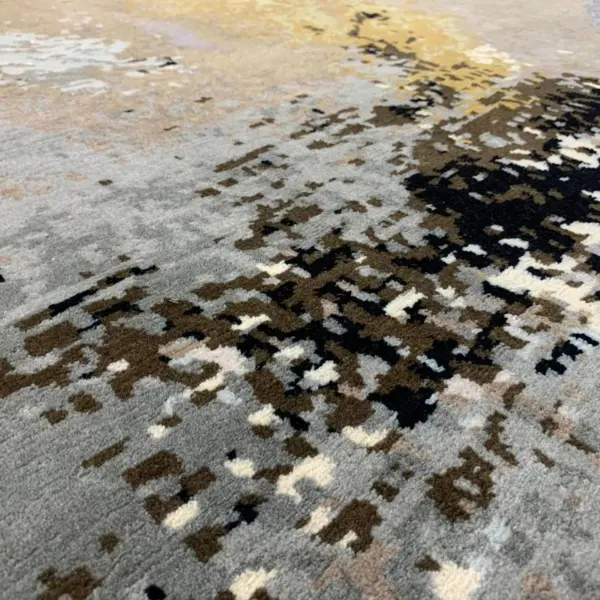 Gros plan sur un tapis noué à la main sur mesure d'après la peinture abstraite de l'artiste Ashley January, dans des tons bruns, gris, blancs et noirs.