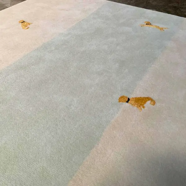 Tapis fait main sur mesure pour un projet de décoration intérieure, dans les tons sauge et crème, avec l'image du chien du client. 