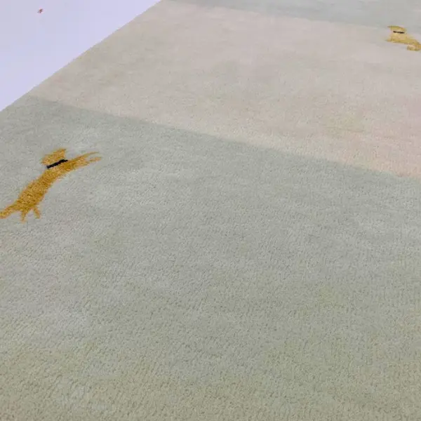 Tapis fait main sur mesure pour un projet de décoration intérieure, dans les tons sauge et crème, avec l'image du chien du client. 