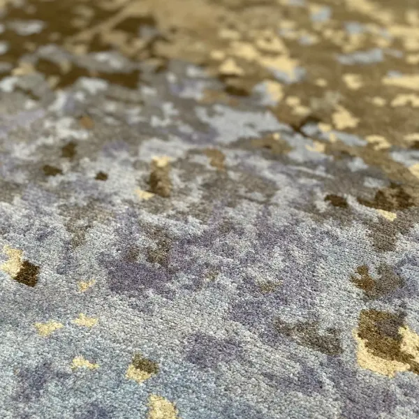 Gros plan sur un tapis fait main sur mesure en gris et jaune d'après la photo d'un sol d'usine du client.