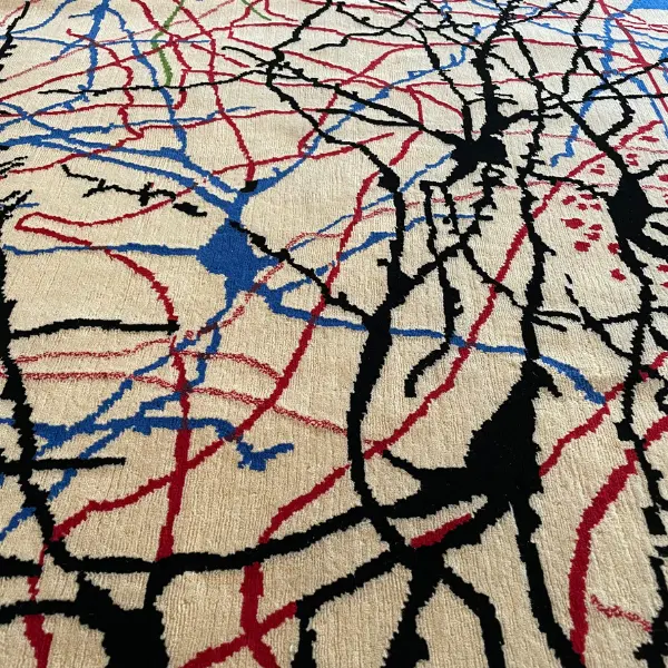 Gros plan d'un luxueux tapis noué à la main d'après le dessin de Ramon y Cajal, beige, rouge, vert, noir, bleu.
