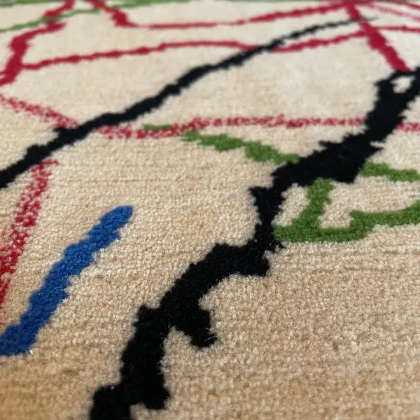 Gros plan d'un luxueux tapis noué à la main d'après le dessin de Ramon y Cajal, beige, rouge, vert, noir, bleu.