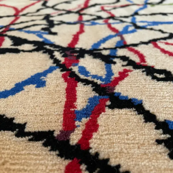 Gros plan d'un luxueux tapis noué à la main d'après le dessin de Ramon y Cajal, beige, rouge, vert, noir, bleu.