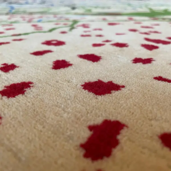 Gros plan d'un luxueux tapis noué à la main d'après le dessin de Ramon y Cajal, beige, rouge, vert, noir, bleu.