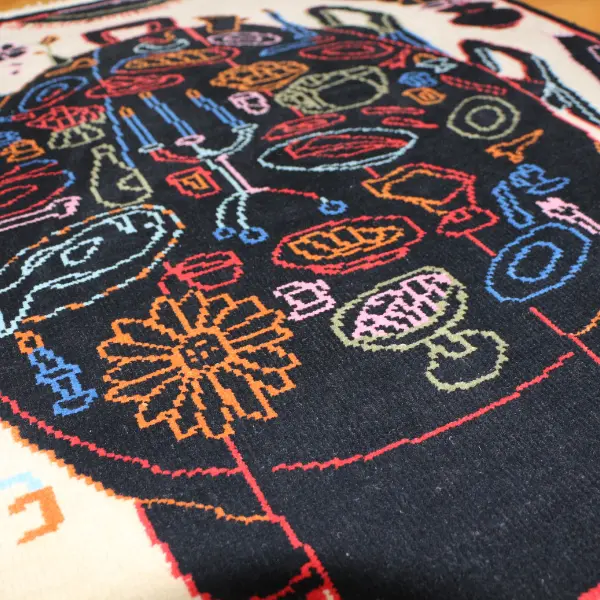 Handknotted rug with black dining table and colourful items in Paris