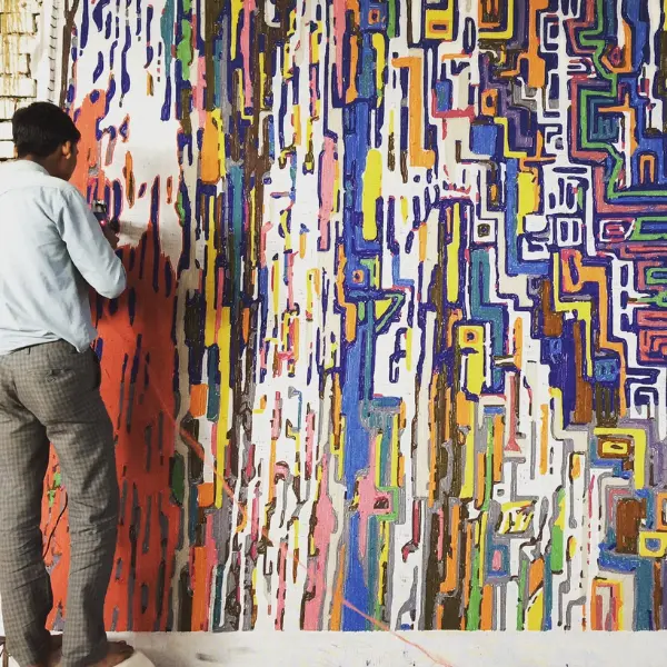 Processus de tufting Tapis tufté à la main avec différentes hauteurs de poils et des lignes arrondies, très coloré rappelant une ville imaginaire.