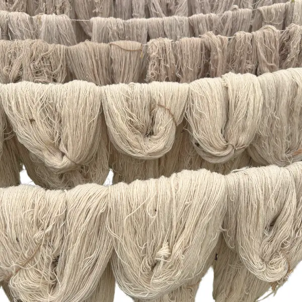 Artisanat dans le processus de création d'un tapis rond fait main sur mesure avec des octogones qui se chevauchent dans des tons variés de beige et de crème.